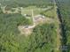 Aerial view of a serene, wooded property with a private driveway and abundant natural beauty at 2676 Will Schronce Rd, Iron Station, NC 28080