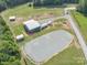 Aerial view of a property with a barn, riding rink, and multiple structures at 2676 Will Schronce Rd, Iron Station, NC 28080