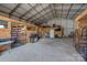 Spacious barn interior featuring wooden stalls, concrete floor, and ample storage space at 2676 Will Schronce Rd, Iron Station, NC 28080
