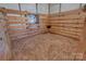 Inside view of an empty wooden barn stall with metal window and a watering trough at 2676 Will Schronce Rd, Iron Station, NC 28080