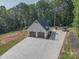 Spacious detached garage with a concrete driveway and basketball hoop, surrounded by lush greenery at 2676 Will Schronce Rd, Iron Station, NC 28080