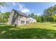 Expansive backyard featuring lush green grass and well-maintained gray siding on this beautiful home at 2902 Oakdale Rd, Charlotte, NC 28216