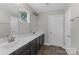 Bathroom featuring double sinks, vanity with dark cabinets, and wood-look flooring at 2902 Oakdale Rd, Charlotte, NC 28216