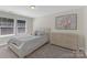 This bedroom features a large bed and dresser with natural light from the windows at 2902 Oakdale Rd, Charlotte, NC 28216