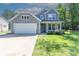 Charming two-story home featuring a well-maintained lawn, attached garage, and inviting front porch at 2902 Oakdale Rd, Charlotte, NC 28216