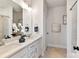 Bright bathroom featuring double sinks, white cabinets, marble counters, and a walk-in shower with glass doors at 330 Armour St # 46, Davidson, NC 28036