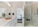 Bright bathroom featuring double sinks, vanity with white marble counters, and glass-enclosed shower with a bench at 330 Armour St # 46, Davidson, NC 28036