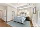 Bright bedroom with wood floors, a large bed with blue patterned bedding, and natural light from multiple windows at 330 Armour St # 46, Davidson, NC 28036
