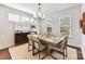 Dining area features large windows, modern chandelier, and a rustic wood table set for six at 330 Armour St # 46, Davidson, NC 28036