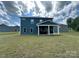 Home's backyard featuring a covered patio, grassy area, and exterior of the house at 348 Ox Bow Cir, Mount Holly, NC 28120