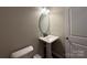 This half-bathroom offers a sleek pedestal sink and classic oval mirror at 348 Ox Bow Cir, Mount Holly, NC 28120