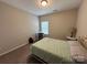 This bedroom features a bed, carpet, desk, and natural lighting at 348 Ox Bow Cir, Mount Holly, NC 28120