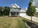 Charming two-story home features a well-manicured lawn, a two-car garage, and inviting front porch at 348 Ox Bow Cir, Mount Holly, NC 28120