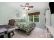 Bedroom with patterned bedding, a ceiling fan, and a bright window view at 3915 Planters Watch Dr, Charlotte, NC 28278
