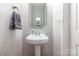 Clean and simple powder room with a pedestal sink and neutral color palette at 3915 Planters Watch Dr, Charlotte, NC 28278
