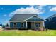 Charming single-story home with blue siding, stone accents, covered porch, and beautifully landscaped front yard at 407 Bent Burr Crk, York, SC 29745