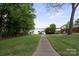 View of the backyard leading to the lake, surrounded by a lush lawn and mature trees at 4516 Kiser Island Rd # 1, Terrell, NC 28682
