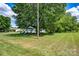 Single-story home with covered front porch surrounded by a large, mature tree on a grassy lot at 5785 Nc 150 E Hwy, Denver, NC 28037