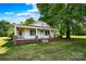 Quaint home with brick foundation, covered porch supported by white columns, and manicured front lawn at 5785 Nc 150 E Hwy, Denver, NC 28037