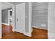 Hallway with hardwood floors, white trim, and doors to the kitchen and closet area at 5785 Nc 150 E Hwy, Denver, NC 28037