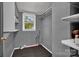 Utility room featuring a window, shelves, plumbing fixtures, and carpeted floors at 5785 Nc 150 E Hwy, Denver, NC 28037