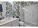 This bathroom features floral wallpaper, a white vanity with a sink, and a glass shower at 6008 Candlestick Ln, Lancaster, SC 29720