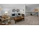 Lofted bonus room features neutral carpeting with sofas, a guitar stand, and decorative wall art at 6008 Candlestick Ln, Lancaster, SC 29720