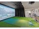 Golf simulator room with dark curtains, artificial putting greens, and a fully equipped bar for entertaining at 6008 Candlestick Ln, Lancaster, SC 29720