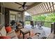 Relaxing covered patio with comfortable seating, ceiling fan, retractable awning and scenic views of the surrounding trees at 6008 Candlestick Ln, Lancaster, SC 29720