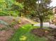 Beautifully landscaped backyard features lush greenery, mature trees, and a stone patio, creating a serene outdoor space at 7040 Edenderry Dr, Charlotte, NC 28270