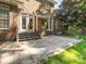 This backyard features a brick home and a stone patio with access to the home through French doors and steps at 7040 Edenderry Dr, Charlotte, NC 28270