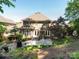 A brick two-story home features a stone patio and landscaped backyard with lush green grass, perfect for outdoor entertaining at 7040 Edenderry Dr, Charlotte, NC 28270