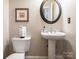 Elegant powder room featuring a pedestal sink, round mirror, and classic fixtures at 7040 Edenderry Dr, Charlotte, NC 28270
