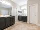 Bathroom features dual vanities with dark cabinets and a neutral tile floor at 7040 Edenderry Dr, Charlotte, NC 28270