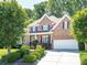 Charming two-story brick home featuring a well-manicured lawn and a spacious two car garage at 7040 Edenderry Dr, Charlotte, NC 28270