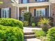 Inviting front entrance with mature shrubbery and brick facade at 7040 Edenderry Dr, Charlotte, NC 28270