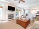 Cozy living room features a fireplace, mounted tv, and doors to backyard at 7040 Edenderry Dr, Charlotte, NC 28270