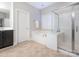 Clean main bathroom with a tub, glass shower, and neutral tile flooring at 7040 Edenderry Dr, Charlotte, NC 28270