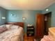 Bedroom with sea-foam walls, hardwood floors, a bed, and shelf with seashells at 739 Owls Den Rd, Lincolnton, NC 28092