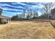 Large, fenced backyard with dormant grass and a partially covered patio at 809 Brown Creek Dr, Matthews, NC 28104