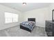 This bedroom includes carpet, a window, a bed with a patterned blanket, and a dark wood dresser at 809 Brown Creek Dr, Matthews, NC 28104
