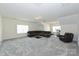 Spacious bonus room with carpeting, multiple windows, and dark leather furniture at 809 Brown Creek Dr, Matthews, NC 28104