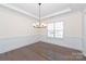 Bright dining room with dark hardwood floors, wainscoting, and modern light fixture at 809 Brown Creek Dr, Matthews, NC 28104