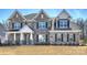 Inviting exterior of stone-accented home with shuttered windows and meticulously maintained front yard at 809 Brown Creek Dr, Matthews, NC 28104