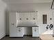 Organized garage with white storage cabinets, drawers, gray countertop and electric vehicle charging station at 809 Brown Creek Dr, Matthews, NC 28104