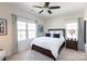 Sunlit bedroom featuring a dark wood bed frame, white bedding, and decorative pillows, creating a relaxing ambiance at 9521 Ainslie Downs St, Charlotte, NC 28273