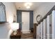 Inviting entryway with a white front door, a wooden staircase, and a charming lamp on an accent table at 9521 Ainslie Downs St, Charlotte, NC 28273