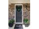 Charming front door with stone accents, a wreath, and potted plants, creating a welcoming entrance at 9521 Ainslie Downs St, Charlotte, NC 28273
