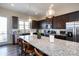 Modern kitchen features a large granite island with bar seating, stainless steel appliances, and sleek dark cabinets at 9521 Ainslie Downs St, Charlotte, NC 28273