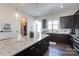 Modern kitchen island with pendant lights, stainless appliances, dark cabinets, and light countertops at 9521 Ainslie Downs St, Charlotte, NC 28273